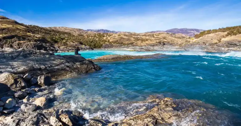 Costa rocosa con agua turquesa bajo cielo azul en Patagonia