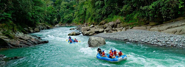Rafting en río turquesa rodeado de rocas grandes y bosque tropical denso, Costa Rica