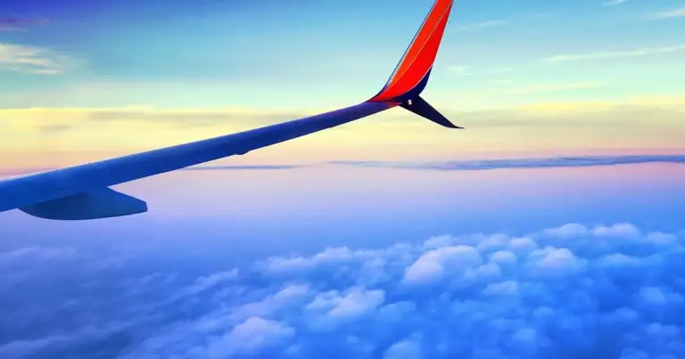 Avion volando sobre nubes - vista del ala desde la ventana