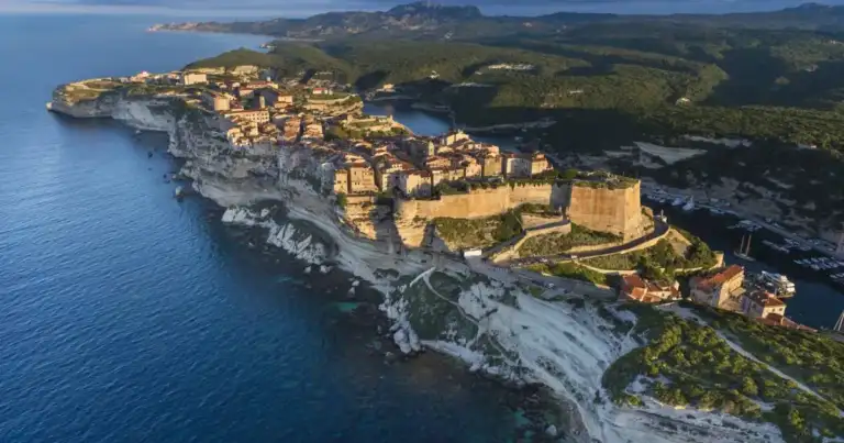 Acantilados blancos sobre mar azul con ciudad costera al norte