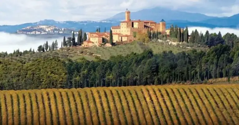 Villa medieval en colina con viñedos y lago en Toscana