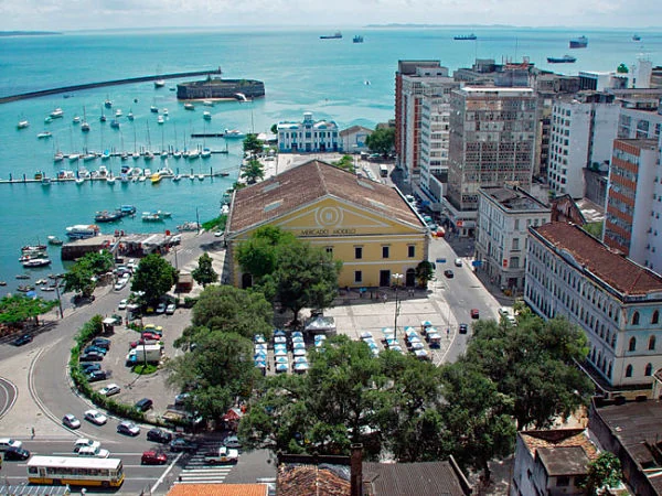 Vista aérea de mercado histórico junto a bahía con barcos, estructura triangular
