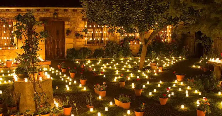 Plaza medieval con decoración de velas iluminadas al atardecer