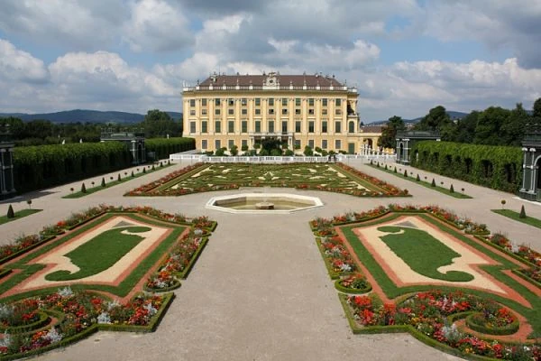 Palacio imperial amarillo claro con jardines geométricos decorados y escalinata