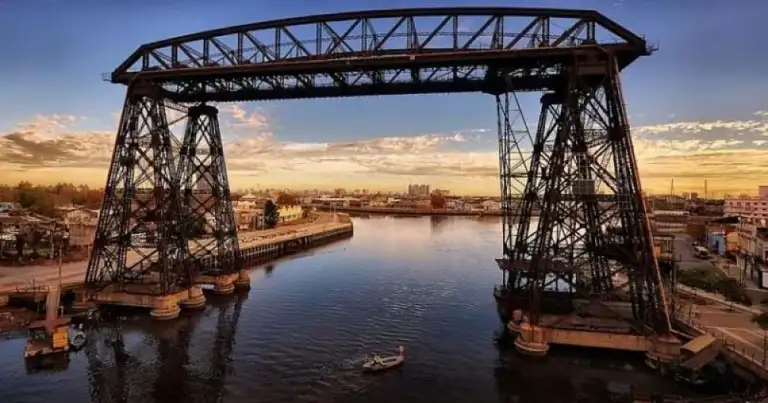 Puente transbordador de hierro sobre río al atardecer