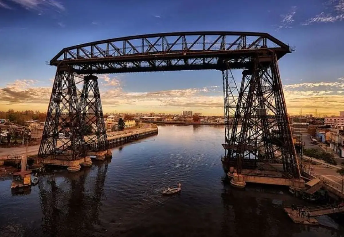 Puente transbordador de hierro sobre río al atardecer