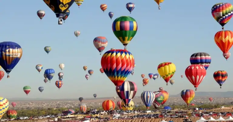 Decenas de globos aerostáticos de colores en vuelo