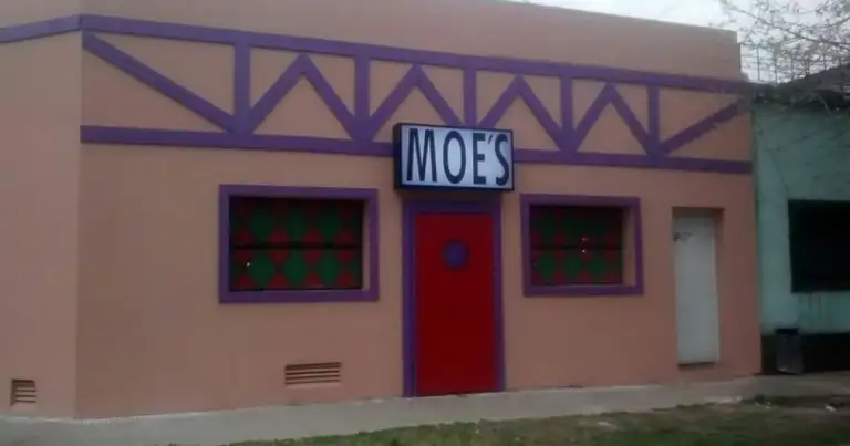 Taberna con letrero MOES en fachada rosa