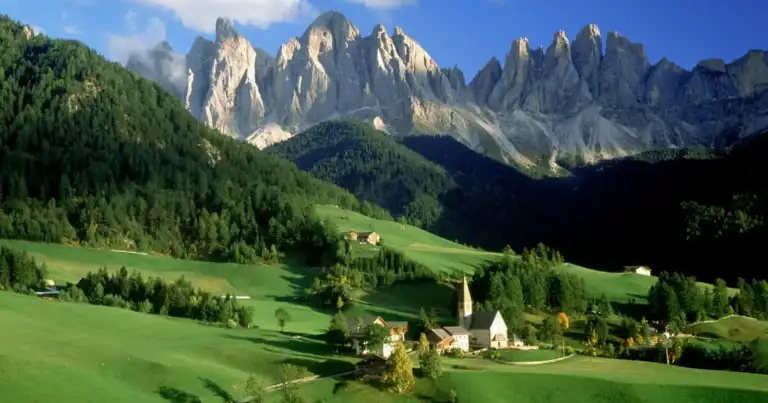 Valle alpino con montañas escarpadas e iglesia pequeña