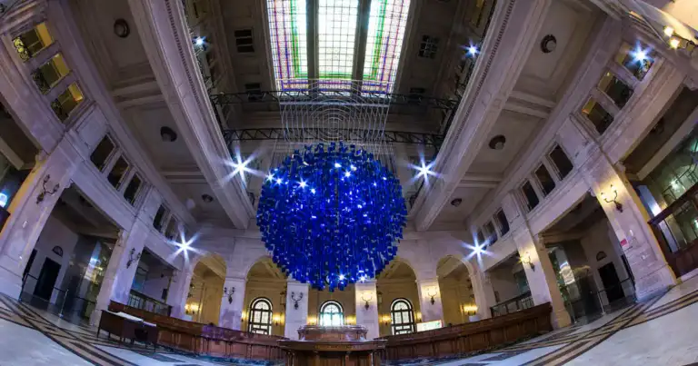 Interior de centro cultural con cúpula vidriada y esfera azul