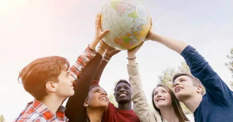 Jóvenes sosteniendo globo terráqueo en grupo
