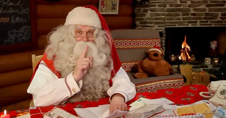 Papá Noel leyendo cartas junto a chimenea