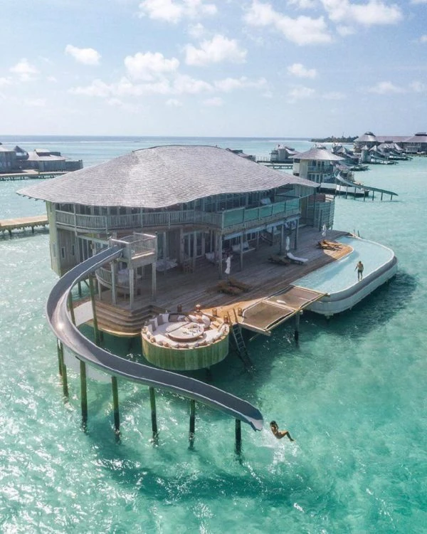 Bungaló sobre agua turquesa con pasarela