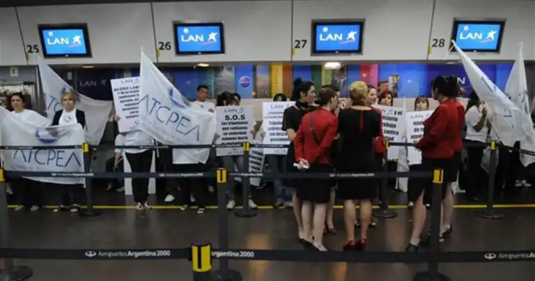 Trabajadores en puerta de aeropuerto con pancartas de huelga