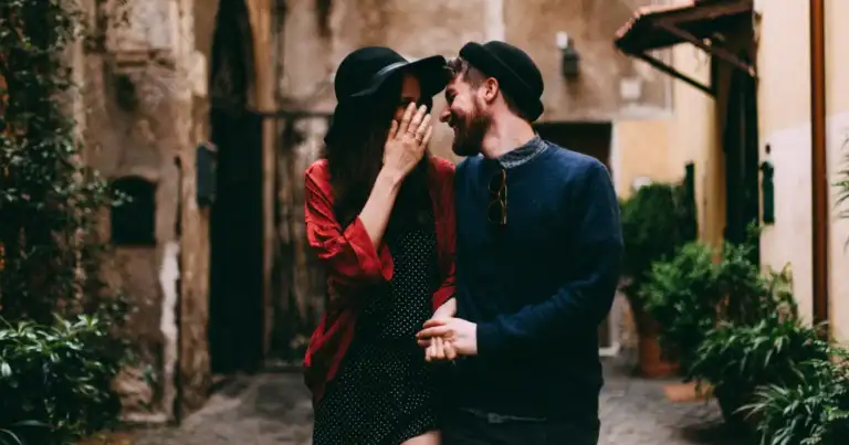 pareja caminando abrazados por una calle empedrada