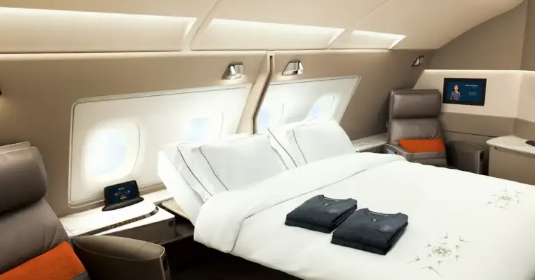 Suite aérea con cama blanca y ventanas de cabina