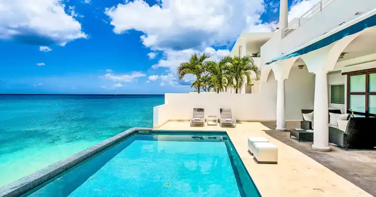 Villa moderna blanca con piscina turquesa junto al mar