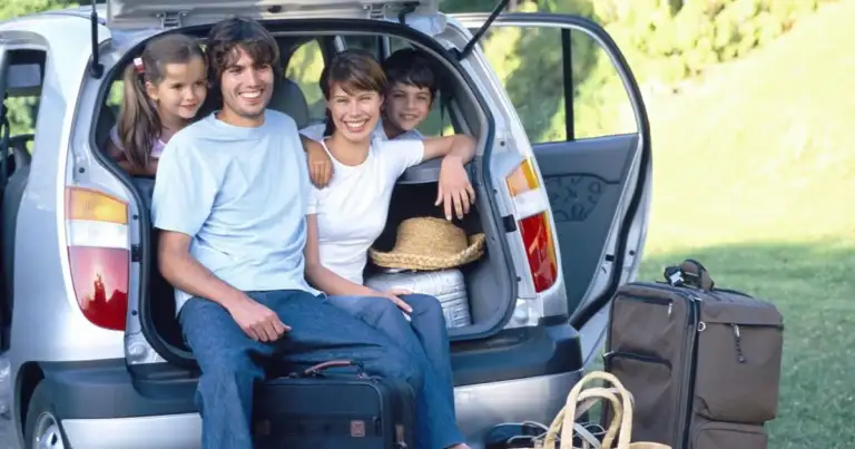 Familia en interior de vehículo en camino rural