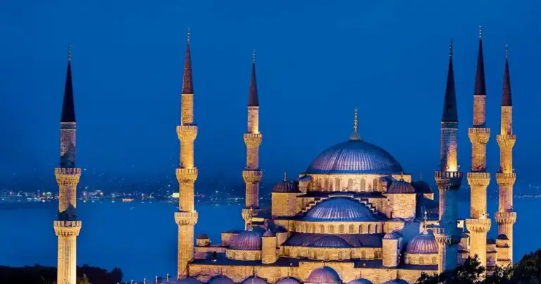 Mezquita Azul de Estambul iluminada de noche con sus seis minaretes y cúpulas.
