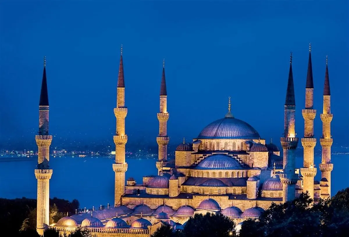 Mezquita Azul de Estambul iluminada de noche con sus seis minaretes y cúpulas.