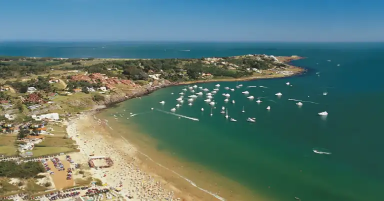 Bahía costera con aguas turquesas, playas arenosas y embarcaciones ancladas