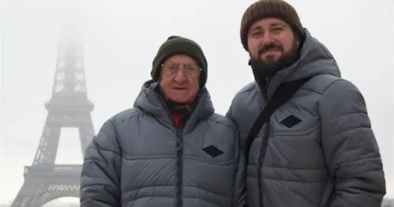 Dos hombres con abrigos de invierno frente a la Torre Eiffel