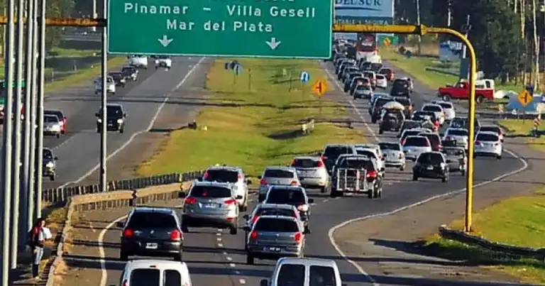 Autopista congestionada con carril de entrada y señal de destinos costeros