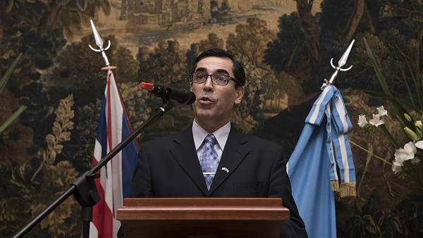 Persona en traje con banderas de fondo