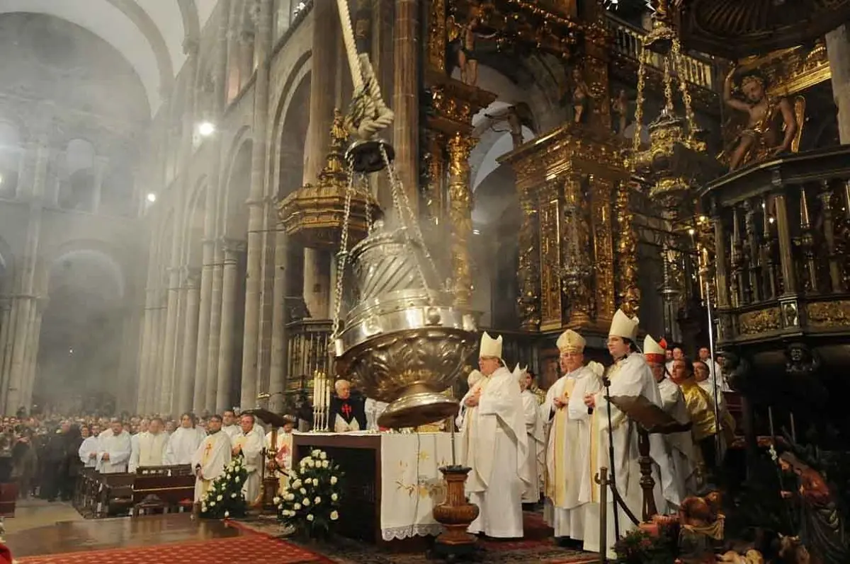 Interior de catedral durante ceremonia con sacerdotes y fieles alrededor de incensario