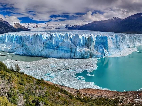 Glaciar de agua turquesa entre montañas nevadas en paisaje patagónico