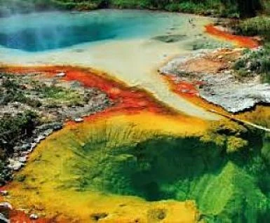 Fuente termal de colores vibrantes: agua turquesa, naranja, amarillo y verde