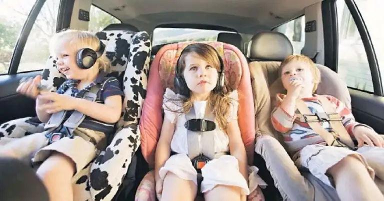 Tres niños en sillas de seguridad en el interior de un automóvil