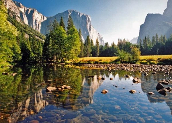 Valle con río reflectante, acantilados de granito y bosque