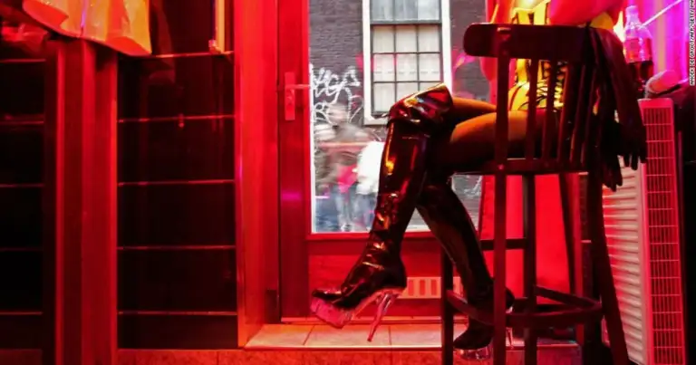 Escaparates rojo neón con figuras del Barrio Rojo de Ámsterdam