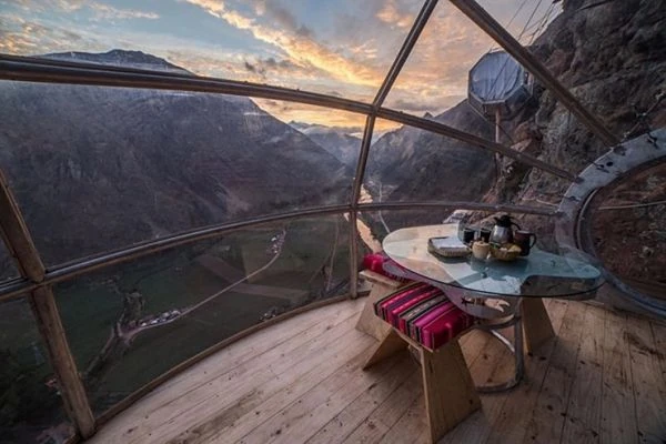 Cama doble dentro de una cápsula transparente con vista a las montañas del Valle Sagrado