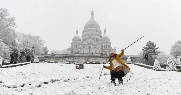 Esquiador frente a Basílica del Sacré-Cœur cubierta de nieve
