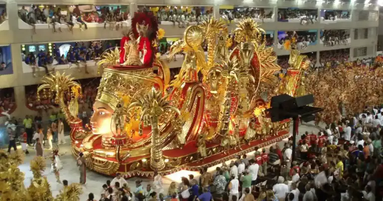 Carroza decorada en desfile de carnaval con bailarines, multitud reunida