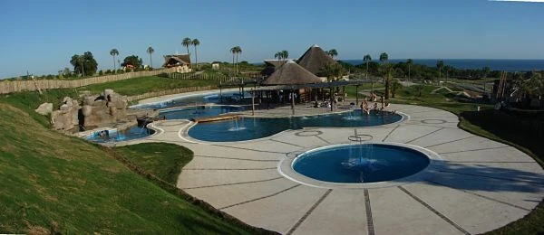 Complejo turístico con piscina azul oval y áreas verdes