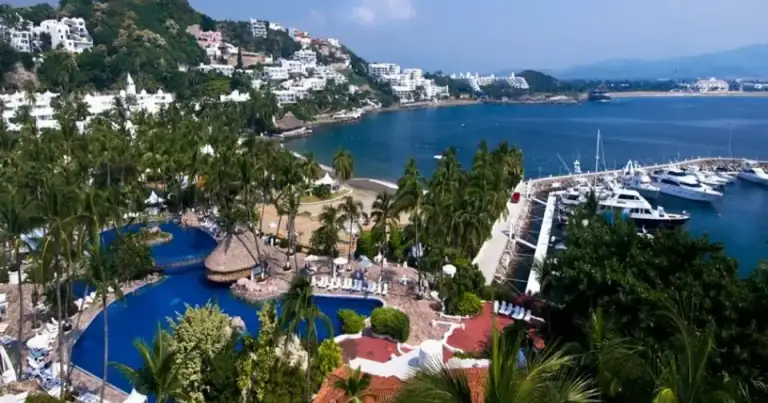 Resort turístico junto a bahía con playas y aguas azules desde vista aérea