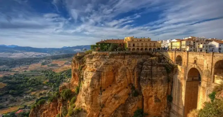 Pueblo de arquitectura dorada construido sobre acantilado de piedra roja