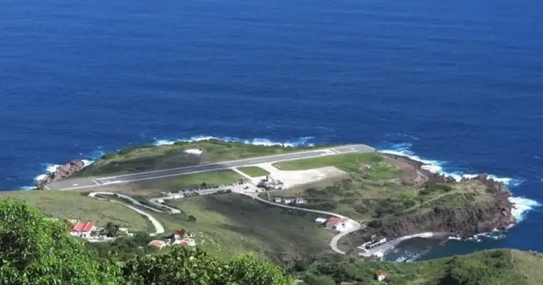 Isla pequeña con pista de aterrizaje rodeada de aguas océano azul