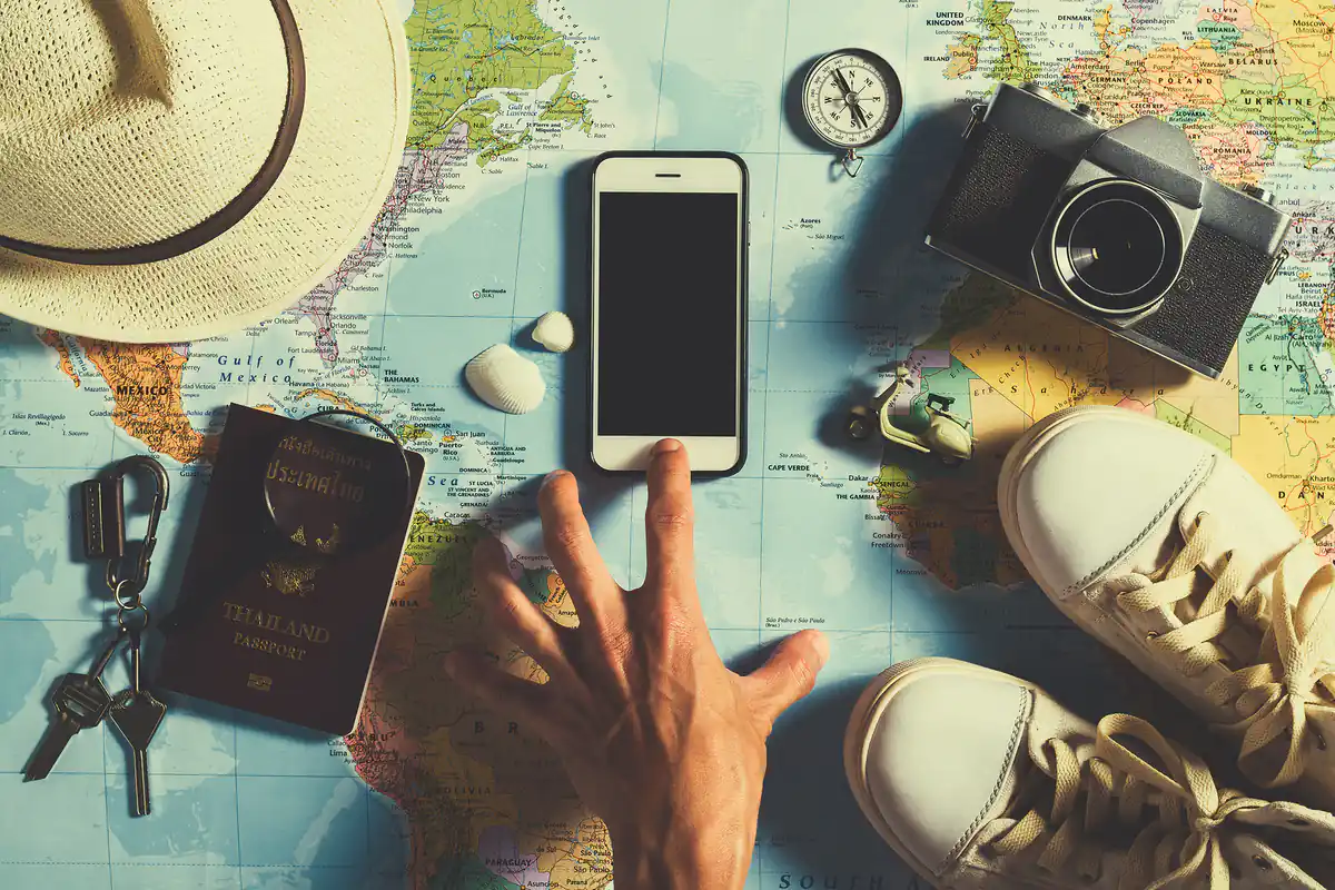 Artículos de viaje organizados sobre mapa incluyendo cámara y pasaporte