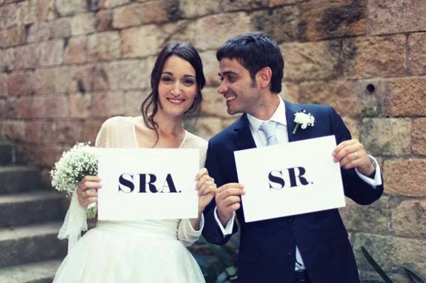 Boda tradicional española Pareja de recién casados saliendo de la iglesia mientras los invitados lanzan arroz