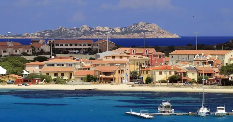 Pueblo costero de arquitectura mediterránea con casas coloridas frente al mar azul
