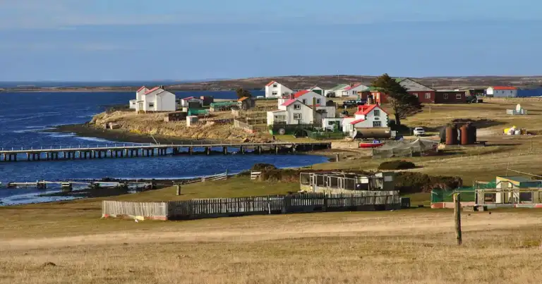 Casas coloridas sobre acantilados rocosos junto al mar en Islas Malvinas