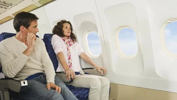 Pareja sentada en cabina de avión cerca de ventanilla durante vuelo