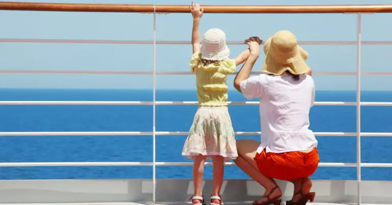 Madre y hija pequeña mirando en la baranda del barco
