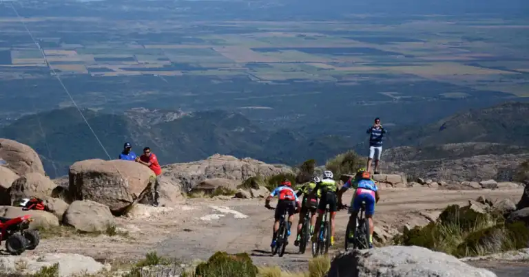 Ciclistas sobre roca de montaña con vista panorámica de valle