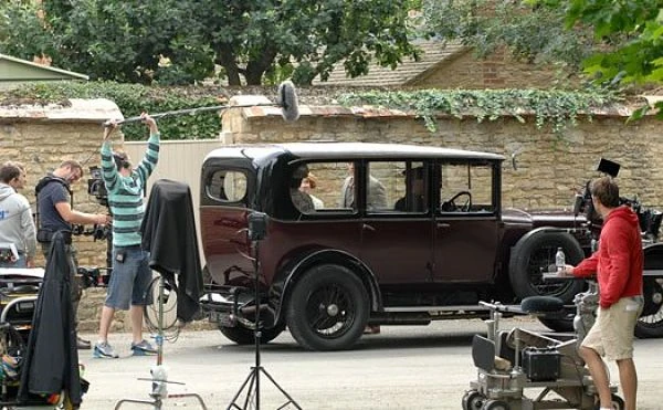 Rodaje de Downton Abbey en Bampton, con un auto antiguo, actores con ropa de época y el equipo de filmación