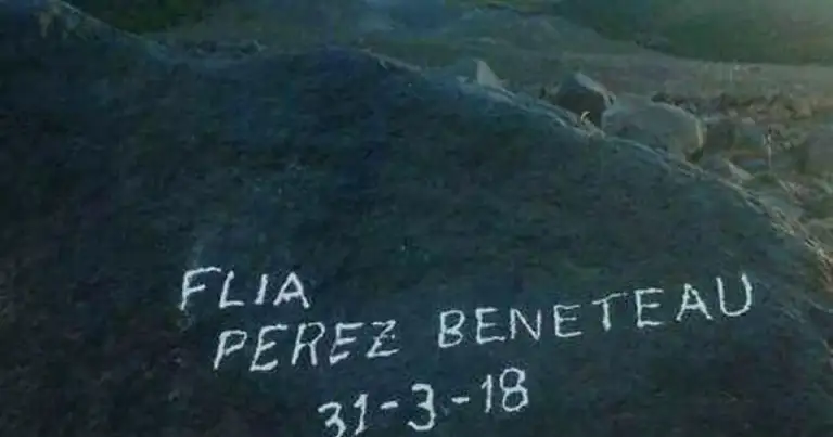 Ladera rocosa con nombres y fecha escritos sobre la piedra